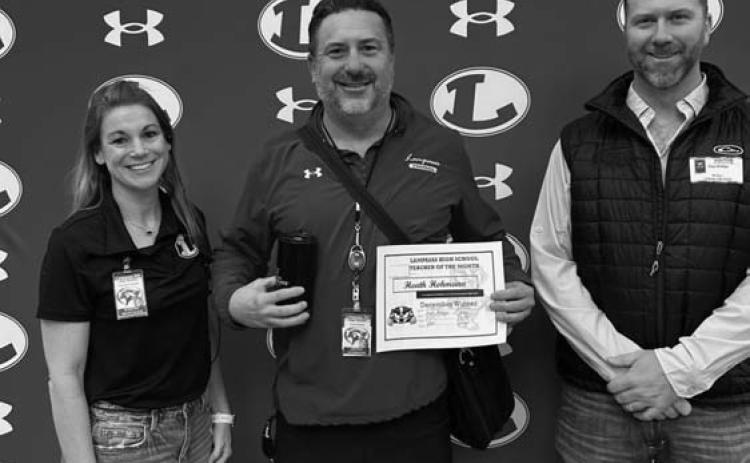 Assistant Principal Kristin Montague and Clay Phillips of Texas Farm Bureau Insurance were on hand to recognize Heath Hohmann as Teacher of the Month for December. COURTESY PHOTO