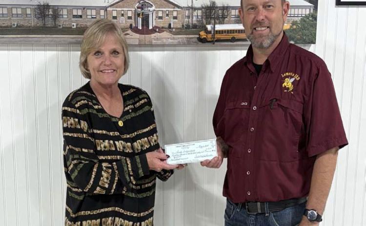 District Clerk Edith Wagner Harrison presents Lometa ISD Superintendent Rob Moore with a check for $19,161. The funds will assist the school district with furnishing supplies for the new automotive program. COURTESY PHOTO