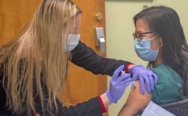 Juana Groat, director of nursing at AdventHealth Rollins Brook, administers a Pfizer COVID-19 vaccine to Michelle Lee. COURTESY PHOTO