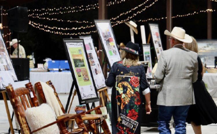 Boots and Blazers Ball attendees scope out items available for auction in last year’s event. FILE PHOTO