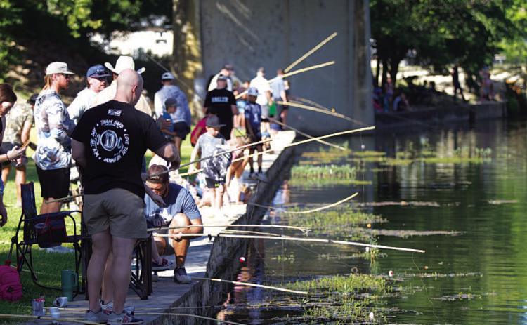 Poles lined the creek in W.M. Brook Park for the fishing derby. HUNTER KING | DISPATCH RECORD