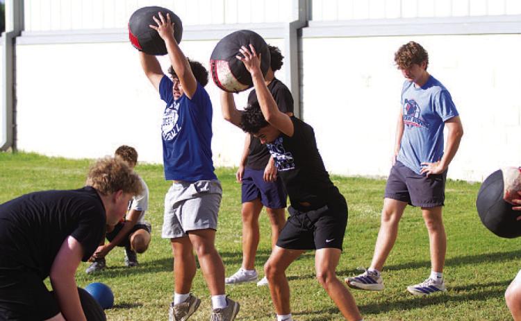 Young Badgers work with medicine balls during SWAT workouts on Wednesday. HUNTER KING | DISPATCH RECORD