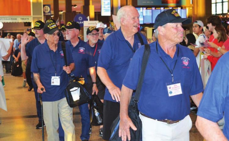 Veterans who participated in an Honor Flight to Washington, D.C. last week were greeted Saturday night by a large crowd at Austin’s Bergstrom International Airport upon their arrival back from the nation’s capital. Lampasas resident James Welch, left side of photograph holding a carry-on bag, served with the Marines during the Korean War. JIM LOWE | DISPATCH RECORD
