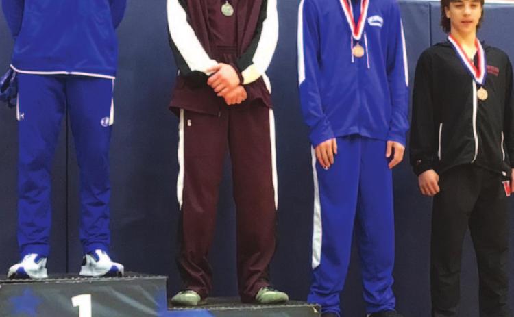 Rylan Myers, left, stands on top of the podium after finishing first during the district wrestling meet last week. COURTESY PHOTO