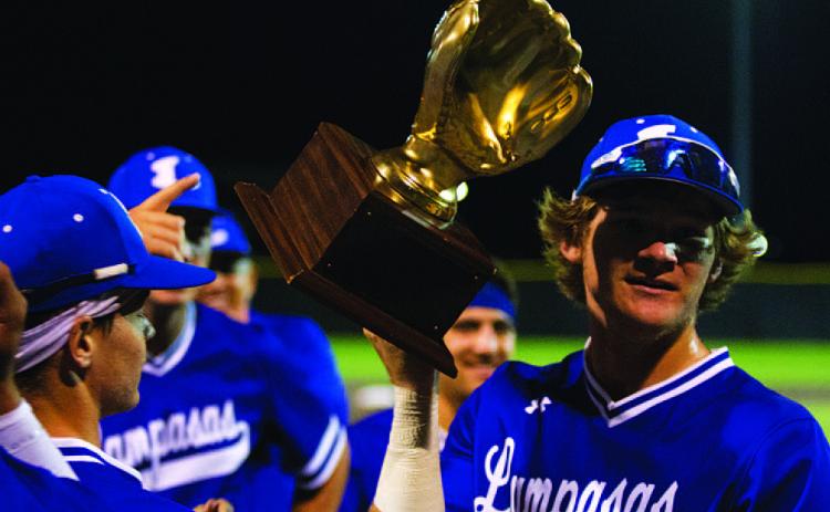 Timber Gholson shows off the gold glove from winning the area round of the playoffs. HUNTER KING | DISPATCH RECORD