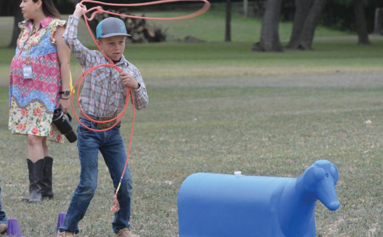 Hanna Springs second-grade student Holt Bumpus practices his lasso skills during Ag Safety Day on Friday. ERICK MITCHELL | DISPATCH RECORD