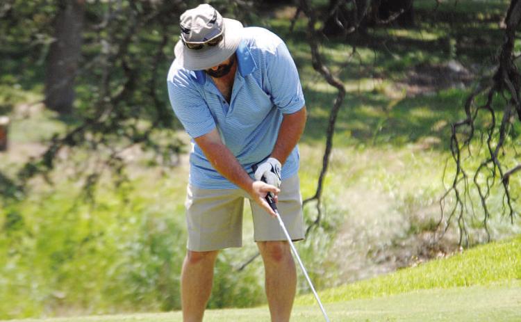 HUNTER KING | DISPATCH RECORD Gerry Spore hits a putt on the fifth green at Hancock Park Golf Course, home of the A.C. January Memorial Tournament.