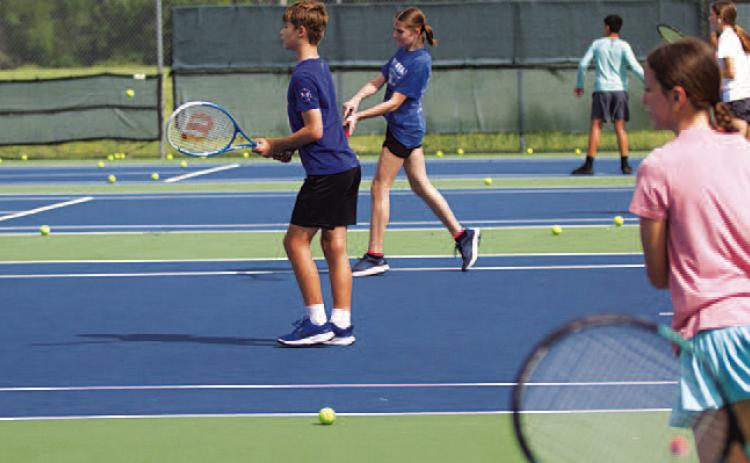 HUNTER KING | DISPATCH RECORD Young tennis players work on their shots during camp on Tuesday.