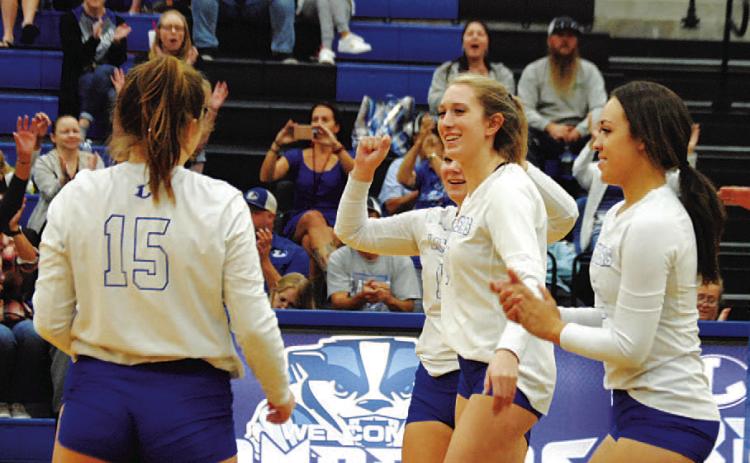 Breana Pelbath and her teammates celebrate a point during Tuesday’s contest. HUNTER KING | DISPATCH RECORD