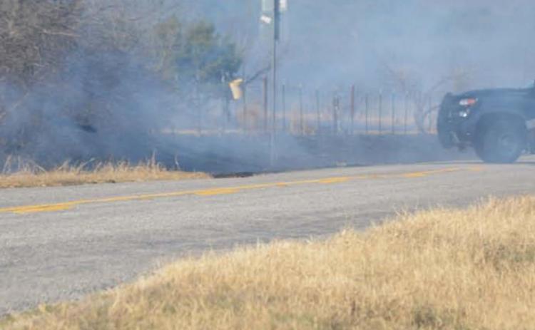 A Lampasas County Sheriff deputy drives through thick smoke during the grass fire that occurred in the county Tuesday afternoon. MONIQUE BRAND | DISPATCH RECORD