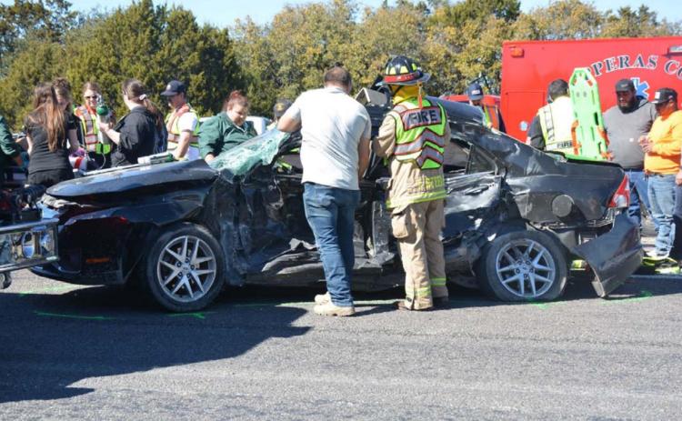 Bystanders aid first responders in reaching two teenagers involved in a fatal crash Tuesday afternoon. One of the teenagers died as a result of the collision on U.S. Highway 190. MONIQUE BRAND | DISPATCH RECORD