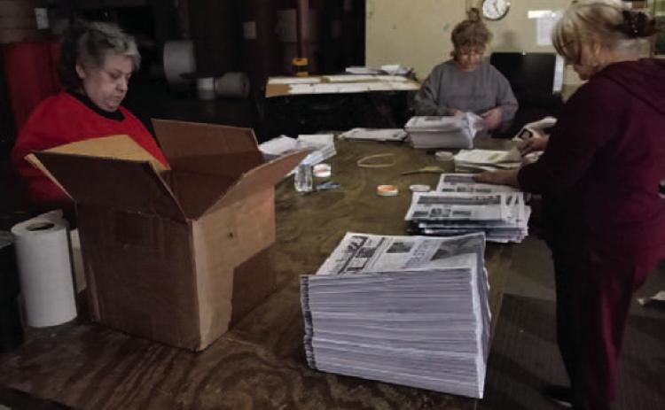 Grace Rangel, left, who has pre-press responsibilities at the printing plant in Taylor; Ory Boney, operations manager; and Janie Mata, inserter, concentrate on getting the Lampasas Dispatch Record and the Boerne Star out the door and back to their respective communities, despite having no electricity at the plant. JIM LOWE | DISPATCH RECORD