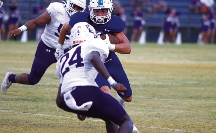 Jett Walker stares down an Elgin defender as he runs toward the end zone. HUNTER KING | DISPATCH RECORD