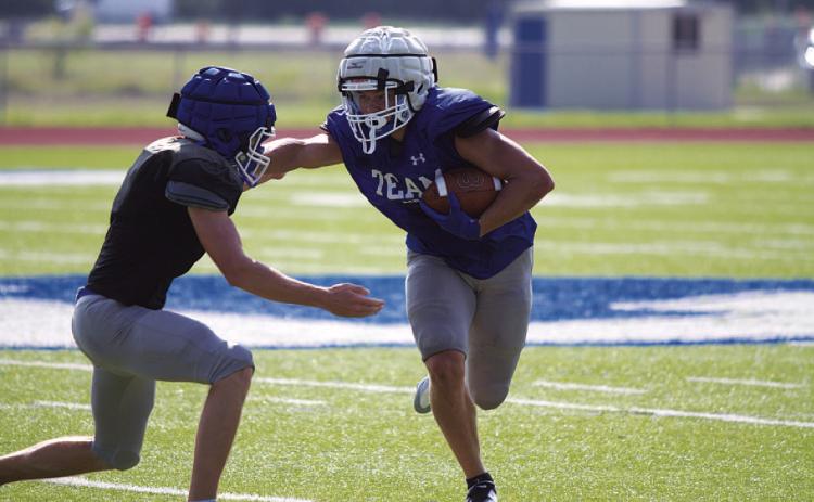 Haegan Oncken throws a stiff arm trying to make a defender miss during Saturday’s scrimmage. HUNTER KING | DISPATCH RECORD