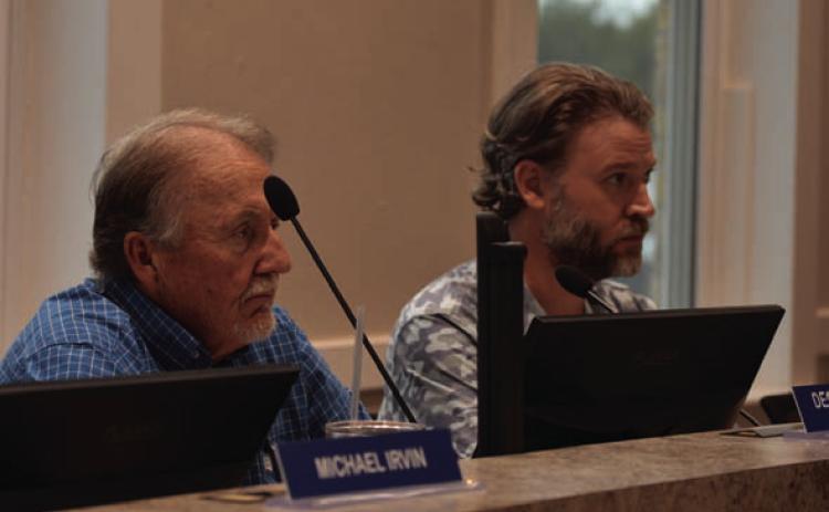 EDC board president Deorald Finney, left, and board vice president Fin Erwin listen to a presentation Wednesday on ways to help building owners pay for costly fire suppression systems and other safety improvements. DISPATCH RECORD