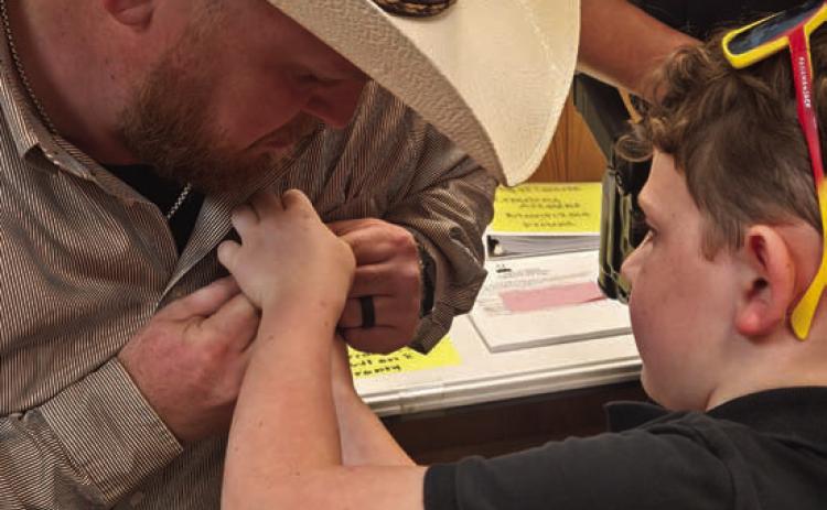 Lometa High School alum C.J. Faubion has his Lometa Police badge pinned by his son, Mavrick. Faubion is one of three new officers named to the force. CHERI JAY-WIENECKE | DISPATCH RECORD