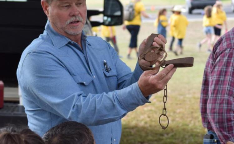 Patrick Flanigan, a wildlife damage management specialist, shows students how a traditional leg trap is set when the USDA Wildlife Service is called in to manage a predator population. ALEXANDRIA RANDOLPH | DISPATCH RECORD