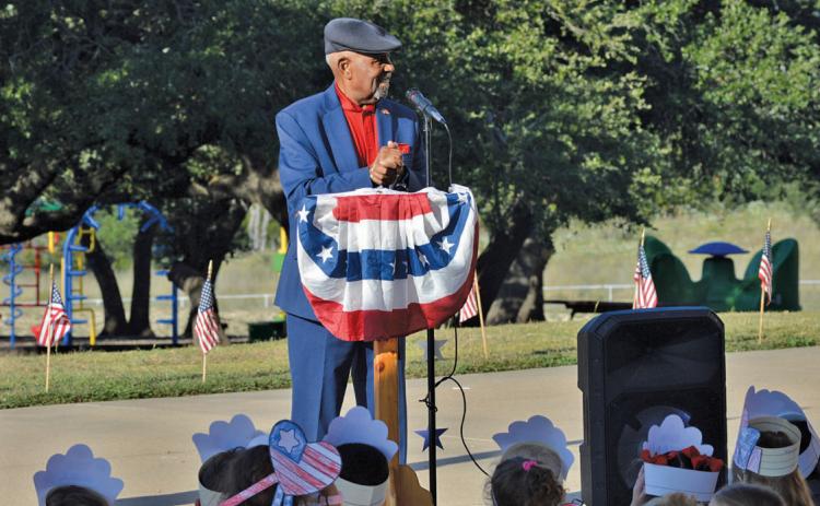 The retired Air Force Chief Master Sgt. Sherman Harper Jr. addresses Taylor Creek Elementary School students on the 24th anniversary of the Sept. 11 terrorist attacks. He also explained the meaning of the colors used in the U.S. flag and encouraged students to honor and respect it. erick mitchell | dispatch record