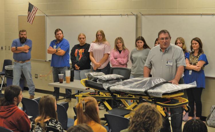 Creating Badger Builders President Herb Pearce speaks to students after the non-profit organization donated a new ECG simulator and stretcher on Tuesday for various CTE programs. erick mitchell | dispatch record
