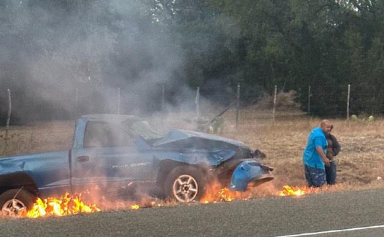 Brandon Roedler helps get a man to safety after he was trapped in a burning vehicle Sunday morning just outside of Burnet on Hoover Valley Road. COURTESY PHOTO