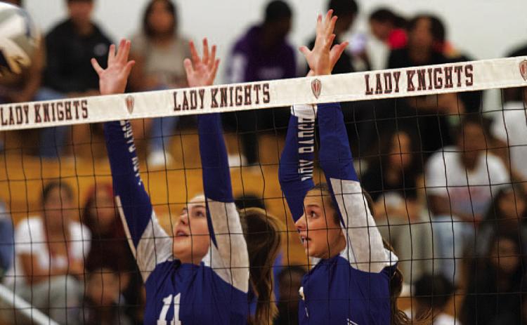 Ava Dowdy, left, and Landry White jump for a block in Harker Heights on Tuesday. HUNTER KING | DISPATCH RECORD