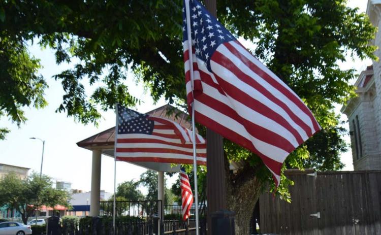 The stars and stripes of the U.S. flag blow in the breeze around the Lampasas County Courthouse last year on Flag Day. FILE PHOTO