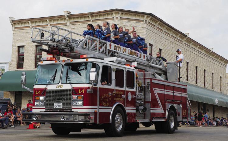 Lampasas High School cheerleaders wave to the crowd atop a Lampasas Fire Department engine during Saturday’s 53rd annual Spring Ho Grand Parade. ADAM BARRIOS | DISPATCH RECORD