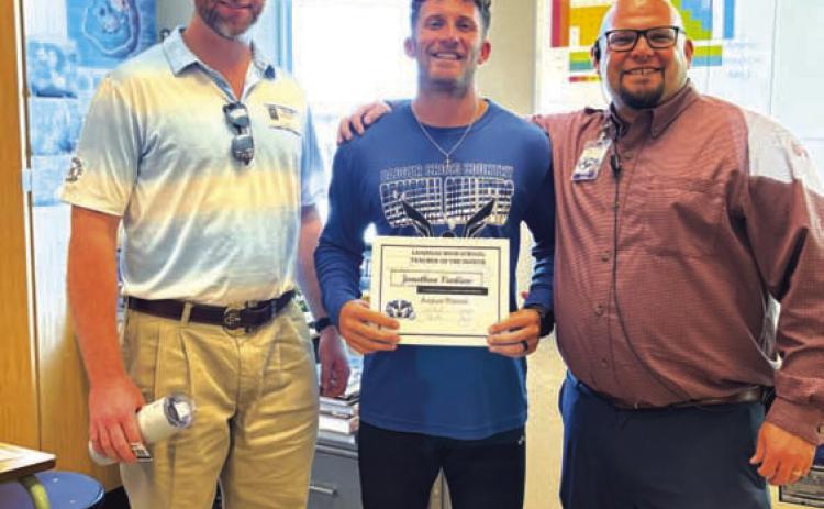 COURTESY PHOTO Lampasas High School selected Jonathan Vanliew, center, as its Teacher of the Month for August. Vanliew teaches biology and chemistry, as well as coaches. On hand to recognize him are Clay Phillips from Texas Farm Bureau Insurance, at left, and Assistant Principal Ryan Race.