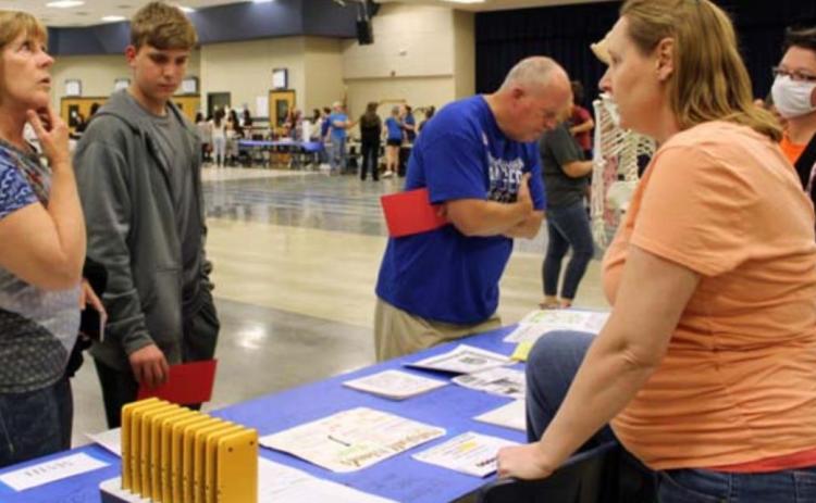 Math teachers Kristina Hopkins and Patricia Bird, at right, discuss different math classes with incoming freshmen and their parents at the Eighth-Grade Night held March 1. FILE PHOTO