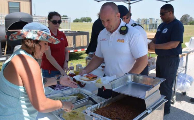 Air Evac member Tawyla Bomar serves Killeen Fire Department Battalion Chief Justin Kemp at last week’s first responder cookout during National EMS Week. MASON HINES | DISPATCH RECORD