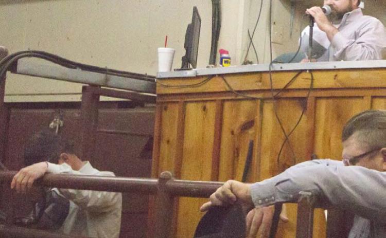Lampasas Cattle Auction owner Andy Baumeister, at back right, prays before starting a Wednesday sale in March 2020, when COVID shutdowns closed many businesses. He has had ownership of the auction business since 2019. FILE PHOTO