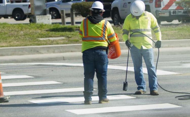 Contractors for the Texas Department of Transportation restripe a crosswalk at the intersection of Key Avenue and Sixth Street. JEFF LOWE | DISPATCH RECORD