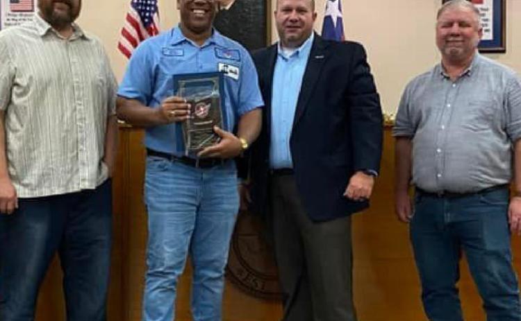 Kempner Iron and Metal manager Walter Gibson, center, holds his Impression Award. He is pictured with city officials, from left, Councilman Dan Long, Mayor John Wilkerson and Councilman Tom Combs. CITY OF KEMPNER FACEBOOK PAGE