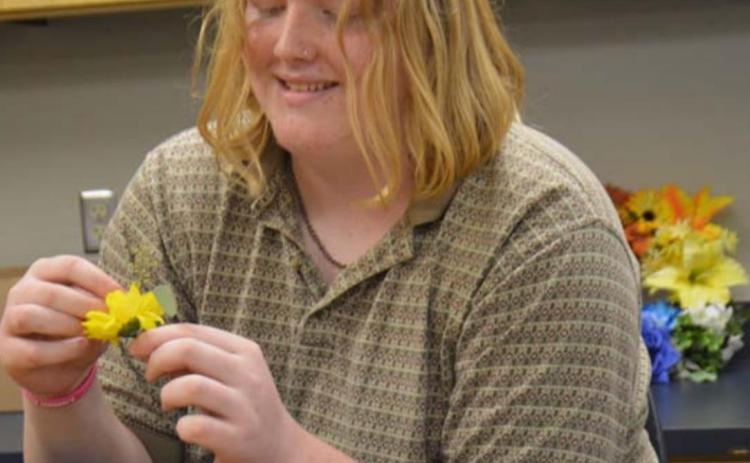 Lampasas High School junior Reighn Webb collects flowers for a project in his floral class Friday afternoon. MONIQUE BRAND | DISPATCH RECORD