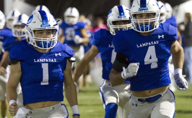 Luke Smith, left, and Aden Rascoe take the field out of the tunnel before the game against Burnet last week. HUNTER KING | DISPATCH RECORD