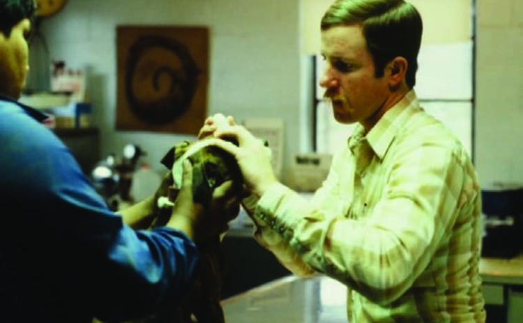 A young Scott Rushing examines a dog at his veterinary clinic. COURTESY PHOTO