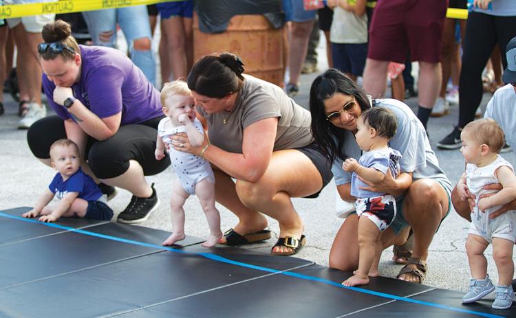 Mothers provide words of encouragement to their little ones before they take on the grueling Diaper Derby event. hunter king | dispatch record