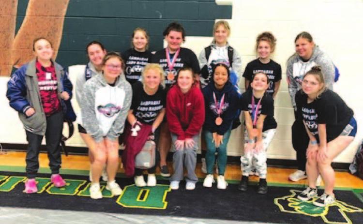 The Lady Badger powerlifting team poses with its medals after finishing in the top half of teams in the region. COURTESY PHOTO