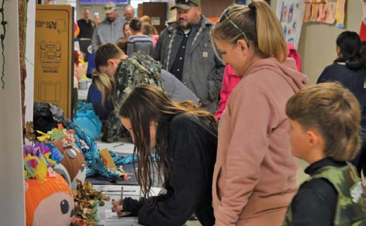 Student-decorated pumpkins line the hallway during Monday night’s Fall Fest at Kline Whitis Elementary. The PTA sponsored a contest, with Police Chief Jody Cummings and Fire Chief Jeff Smith serving as judges. Pumpkins were auctioned afterward. erick mitchell | dispatch record