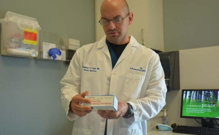 Dr. Stephen Vogel, a physician at AdventHealth Central Texas Family Medicine Clinic-Lampasas, handles a box of Moderna vaccines in his office Thursday. MONIQUE BRAND | DISPATCH RECORD