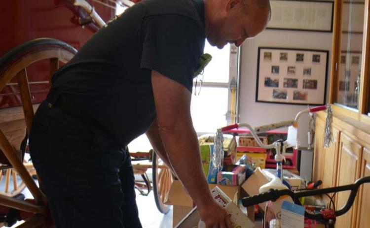 Lampasas firefighter Sean Schroeder sorts toys inside the fire station on Friday. Distribution to families that have applied will take place Dec. 18. Kempner residents may sign up for toys at the fire station there. Families in Lometa who would like to receive gifts should contact Lometa City Hall to participate in the toy drive. In Adamsville, area churches can assist families in need. MONIQUE BRAND | DISPATCH RECORD