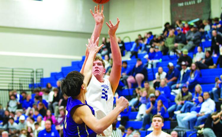 HUNTER KING | DISPATCH RECORD Beau Patterson shoots over an outstretched hand as the crowd watches behind him.