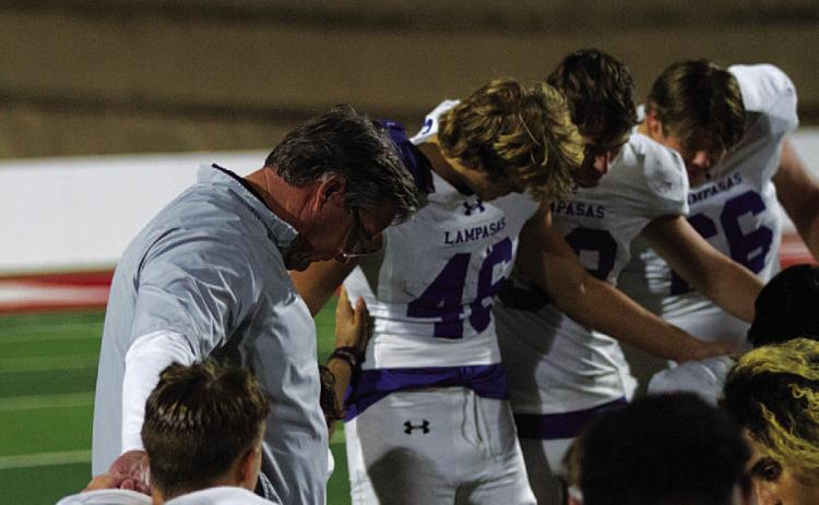 HUNTER KING | DISPATCH RECORD Head coach Troy Rogers bows his head to pray with his team after last Friday’s playoff game.