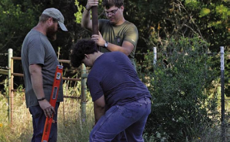 Brennen Barber helps install a 32-foot pole into the ground at Kempner’s Sylvia Tucker Memorial Park on Friday morning. Barber installed two poles for his bat-box project, with each pole able to hold two boxes. ERICK MITCHELL | DISPATCH RECORD