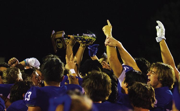 The Badger football team raises their new golden football after winning over Pecos last Thursday night. HUNTER KING | DISPATCH RECORD