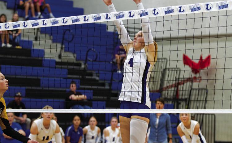 Brylie Turner leaps for a block during Tuesday’s match against the Lady Hornets. She also led the team in kills. HUNTER KING | DISPATCH RECORD