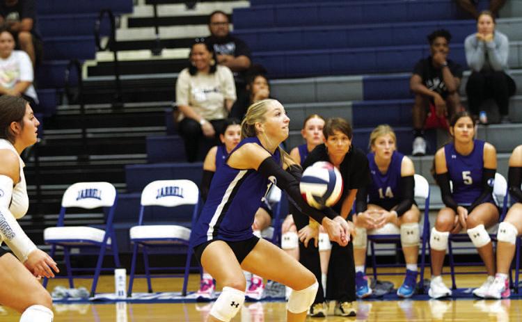 HUNTER KING | DISPATCH RECORD Brailey Wilson makes a pass as head coach Christy Wiley watches on from the bench.