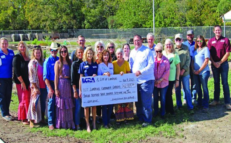 Lampasas Community Garden Director Janet Crozier stands in center, between Mayor Herb Pearce and LCRA representatives Carol Freeman and Meg Voelter to receive a grant for projects and improvement for the garden.