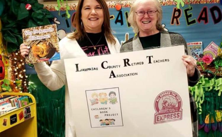 Kline Whitis Elementary School librarian Barbara Moncus, left, holds a copy of the book “Why Do Animals Hibernate?”, which the Lampasas County Retired Teachers Association provided last year to kindergarten students in Lampasas and Lometa schools. Retired teacher Julia Phillips, at right, is soliciting help from other retirees in the area so the book donations can continue in 2021. COURTESY PHOTO