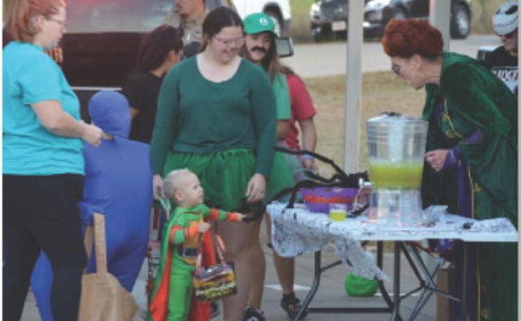 At right, Kempner City Manager Rebecca Ramos helps a trunk-or-treater to a cup of punch during last year’s event. This year’s event will take place at the Sylvia Tucker Memorial Park. courtesy photo | Johnny Anderson
